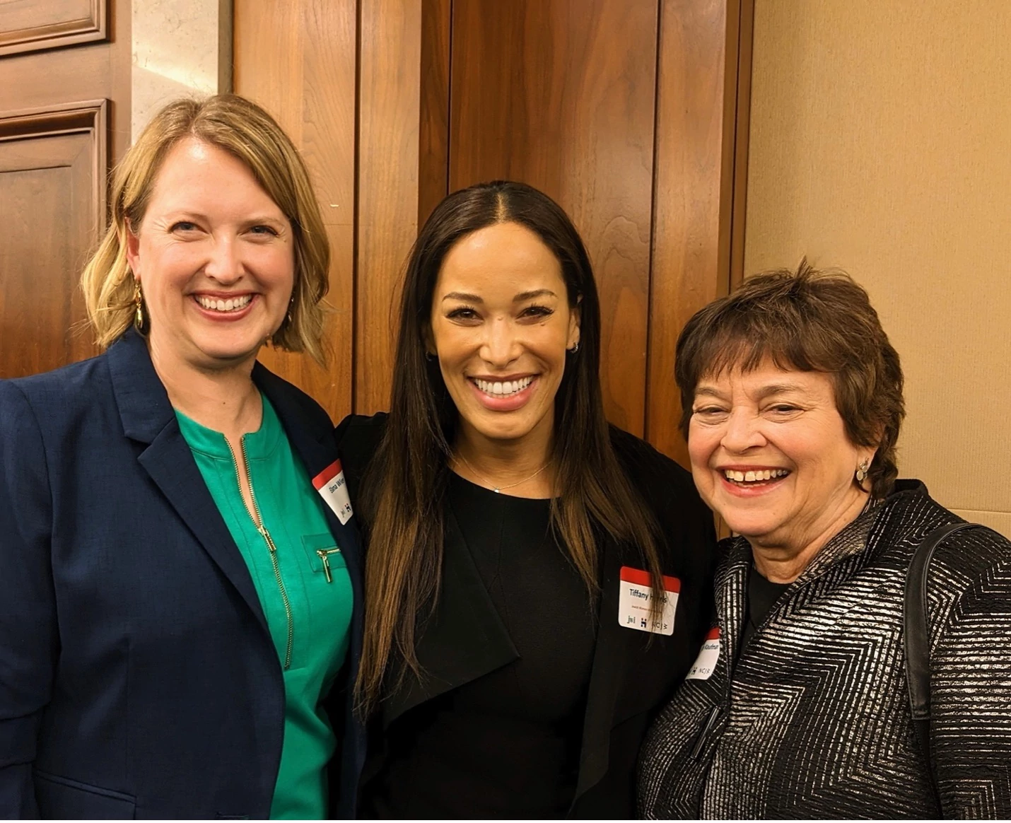 Three Jewish leaders stand together smiling.