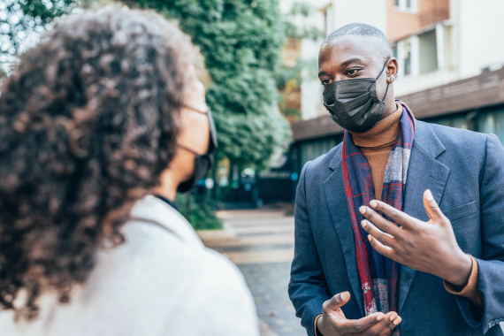 People wearing face masks, conversation on a city street