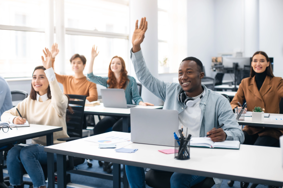 Students in classroom raising their hands