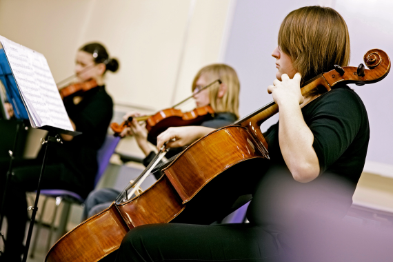 Advocating for the Arts, students playing violins and cello in an orchestra