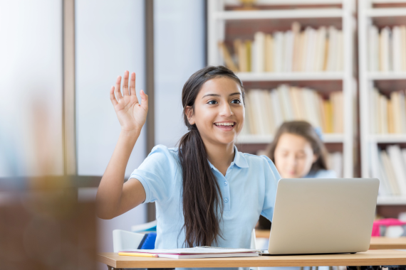 Teacher sits with young student to work on a problem