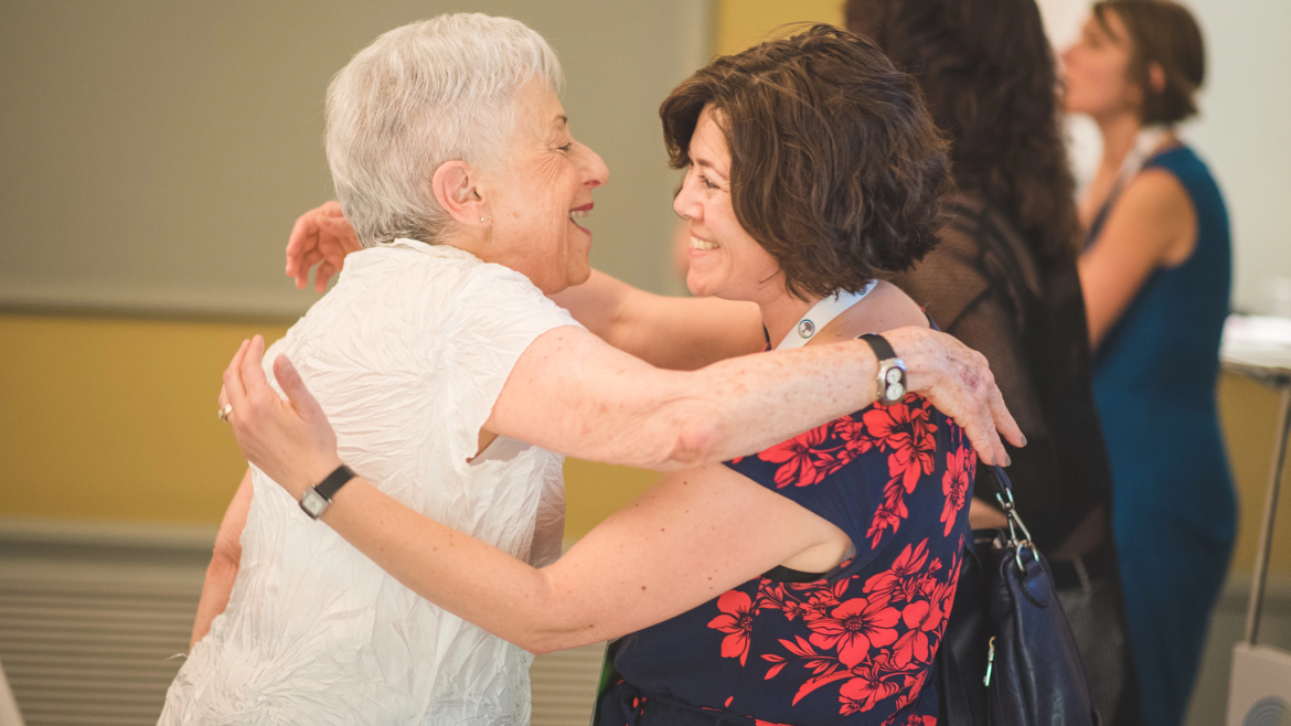 Two women hug in greeting