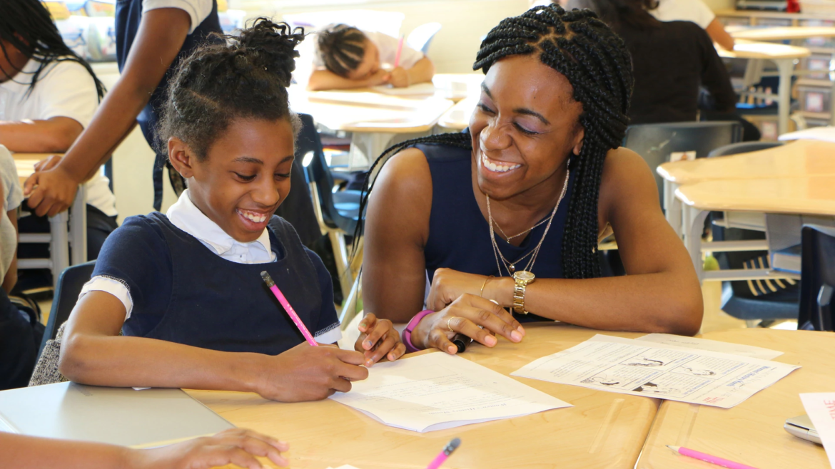 Smiling teacher assisting smiling student