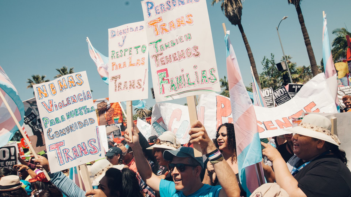 People with signs in Spanish for trans equality, respect, no more violence