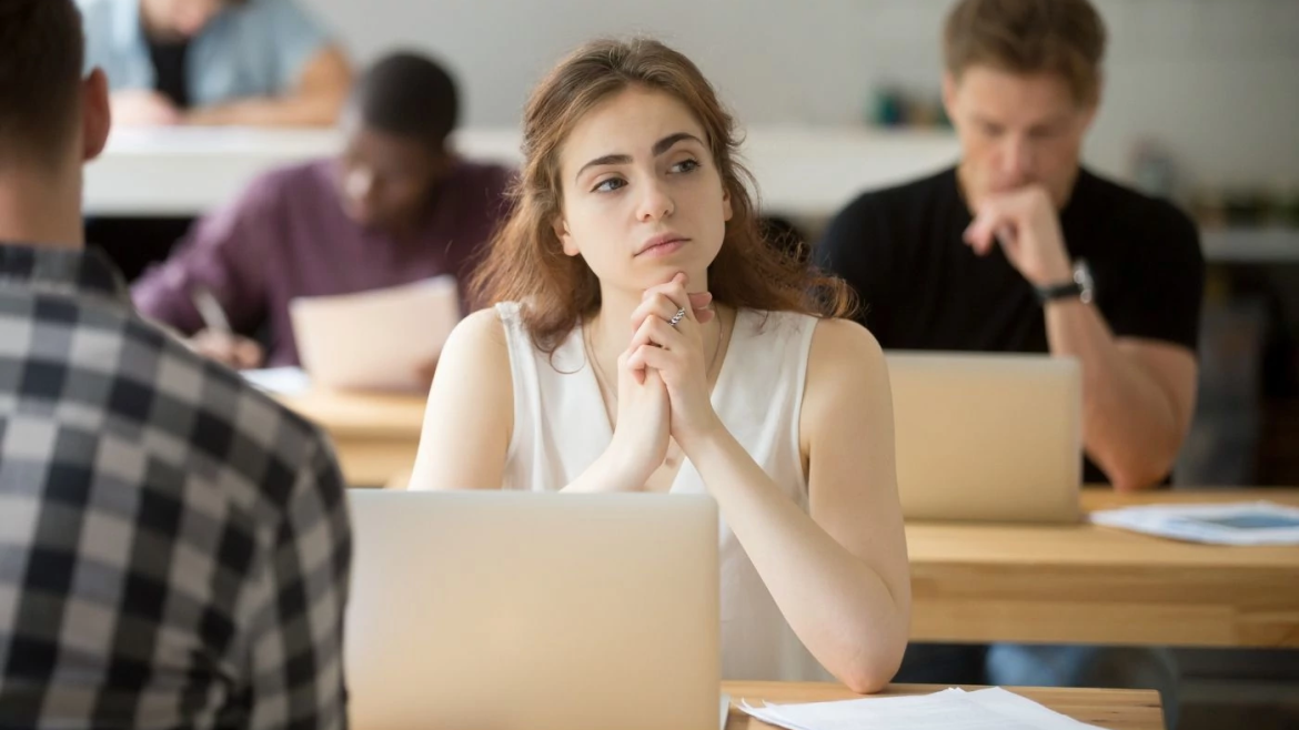 College student in contemplative pose at her desk