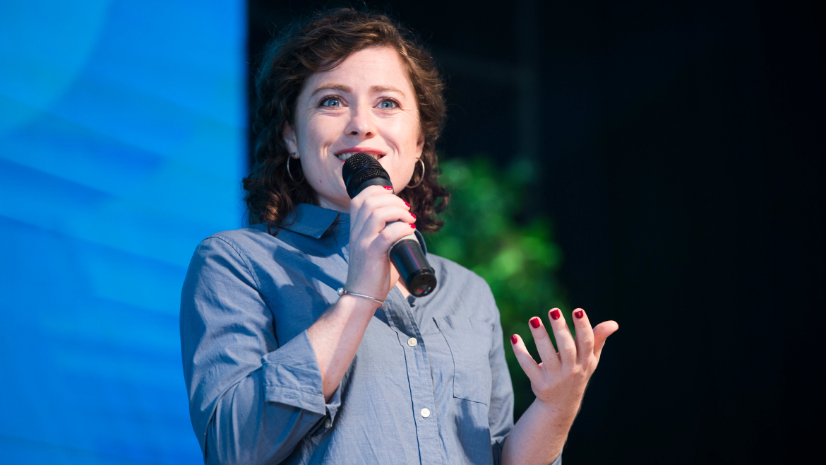 Smiling young woman speaking on stage