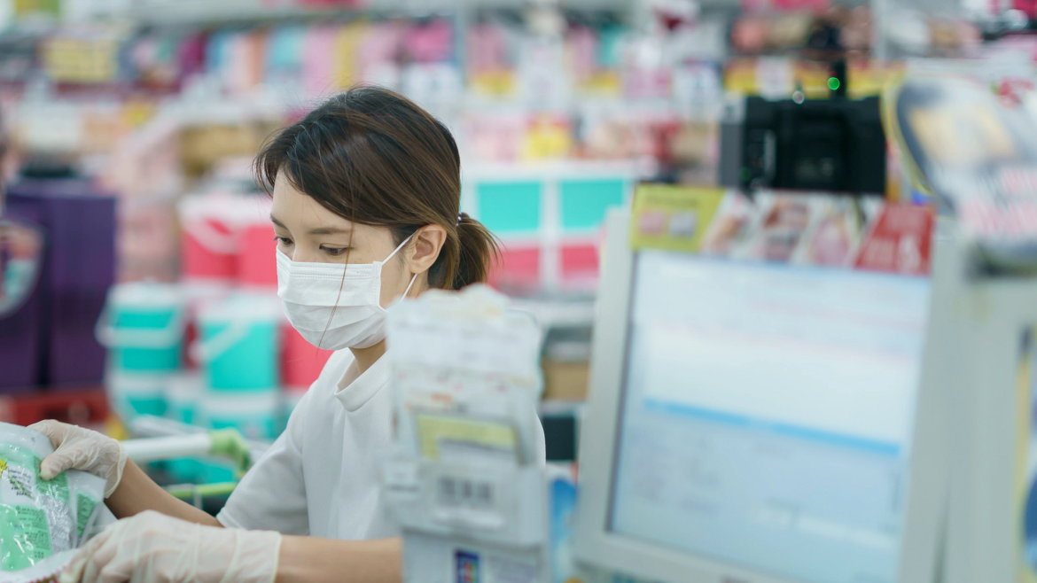 Woman cashier working while wearing mask and gloves