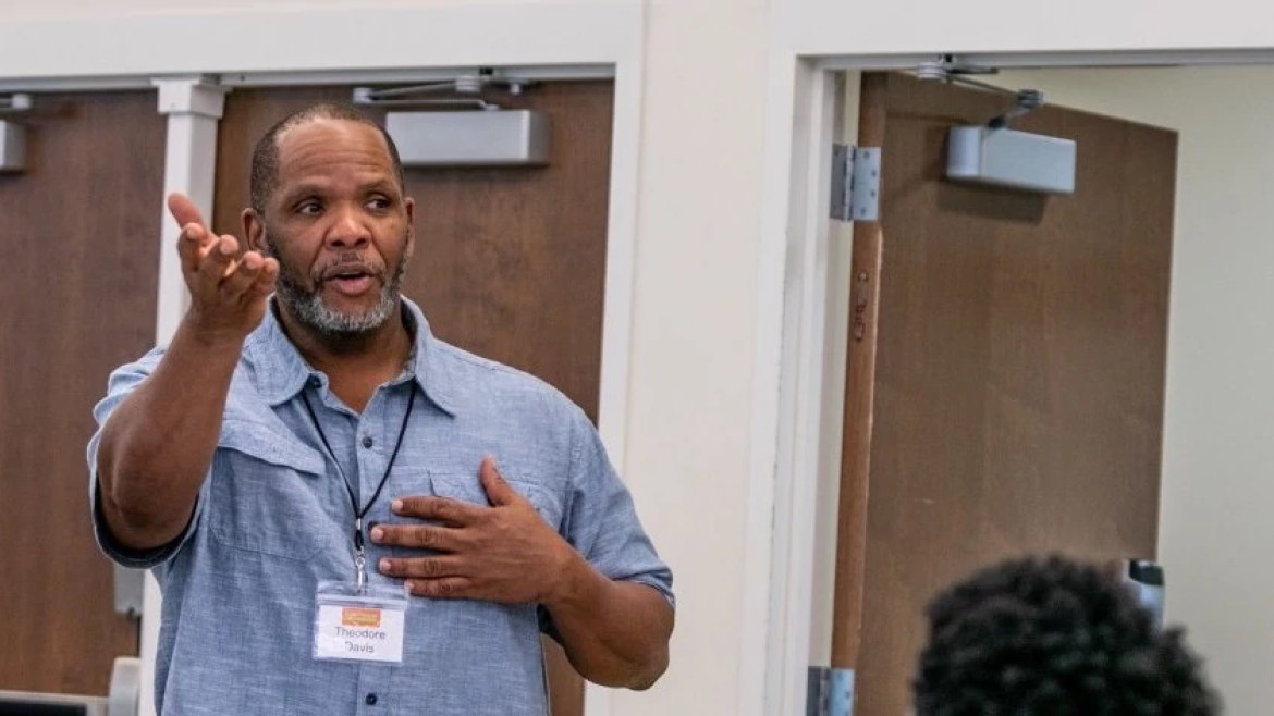 Man speaking to other teachers in a classroom