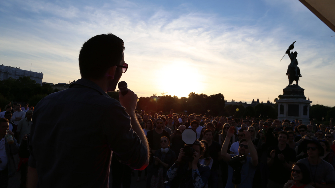 Ilja speaking before a crowd in a park
