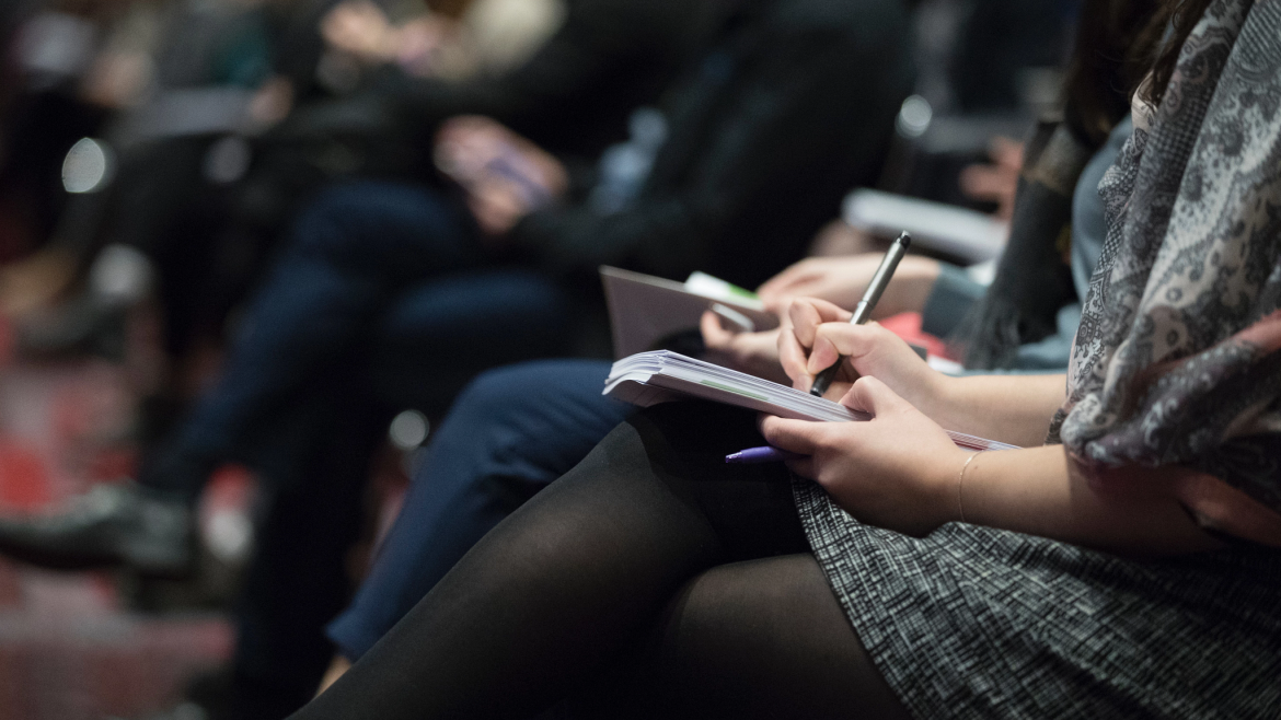 Conference attendees - taking notes in the audience