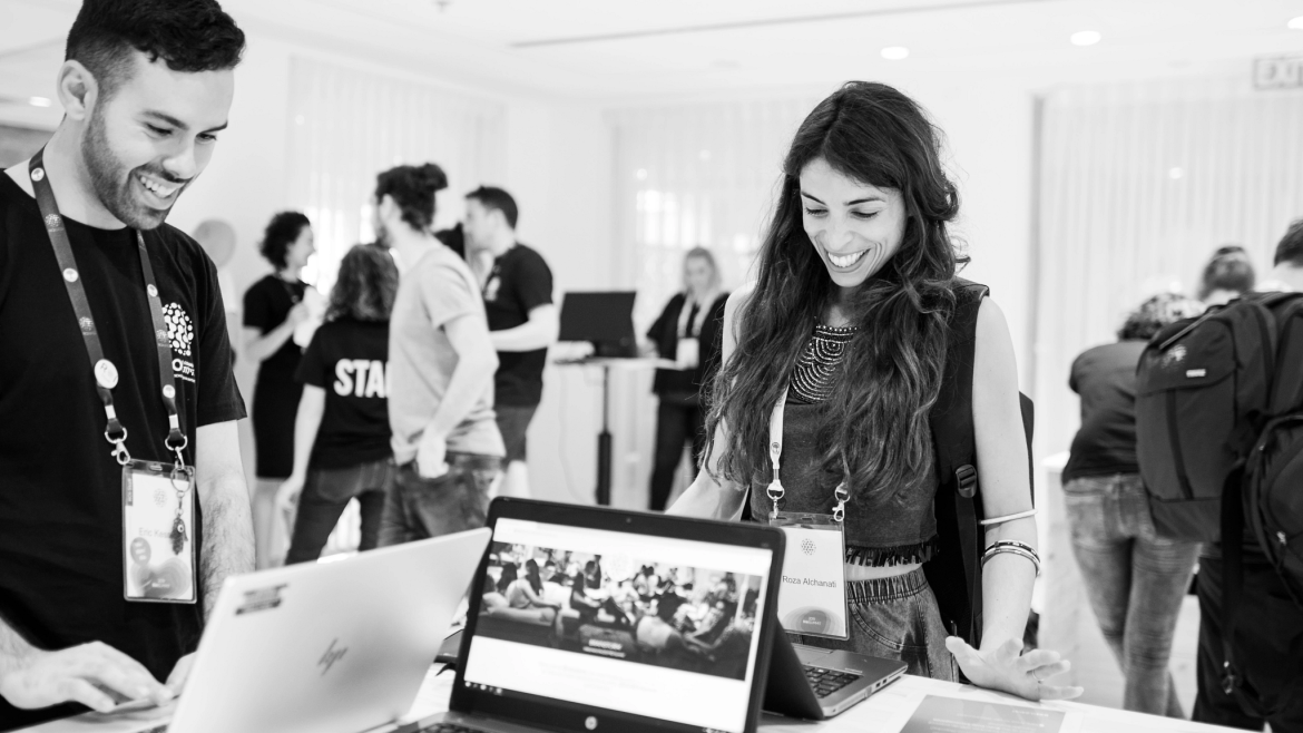 Smiling ROI participants using laptops