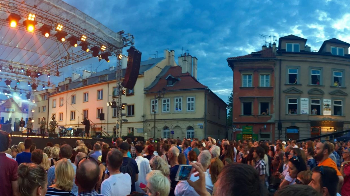 Outdoor stage and attentive crowd as night falls on the Krakow Jewish Culture Festival