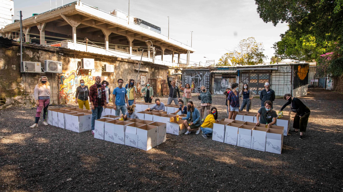 Volunteers in medical masks prepare bins for a giving event in Tel Aviv