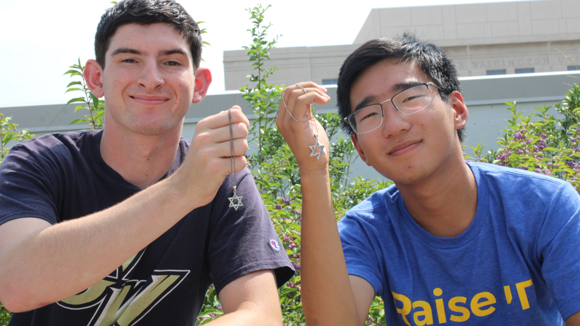 Two young men smiling with their Magen David necklaces