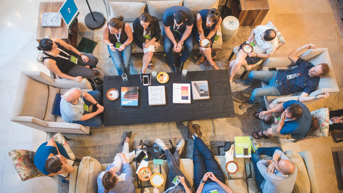 Viewed from above, a group socializing, couches, coffee table