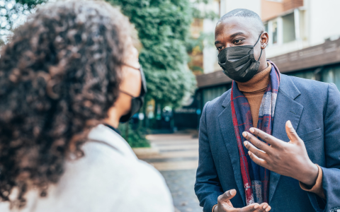 People wearing face masks, conversation on a city street