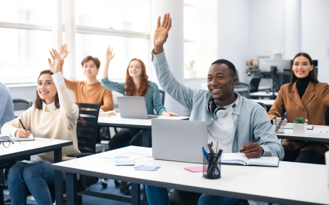 Students in classroom raising their hands
