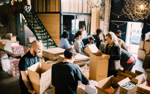 10-15 people pack boxes as part of a volunteer project.