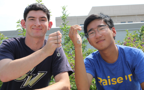 Two young men smiling with their Magen David necklaces