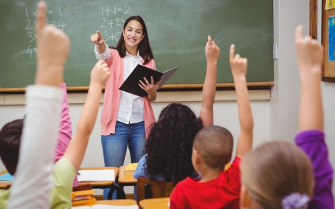 teacher in front of classroom - ed trust